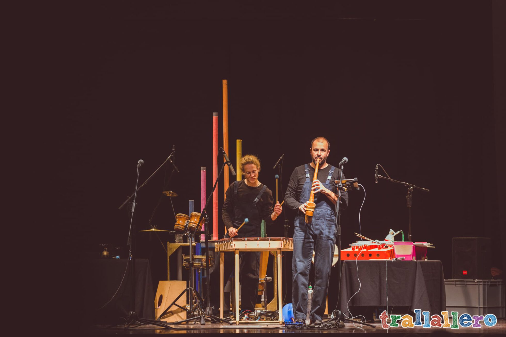 attori in scena che suonano strumenti musicali inventati