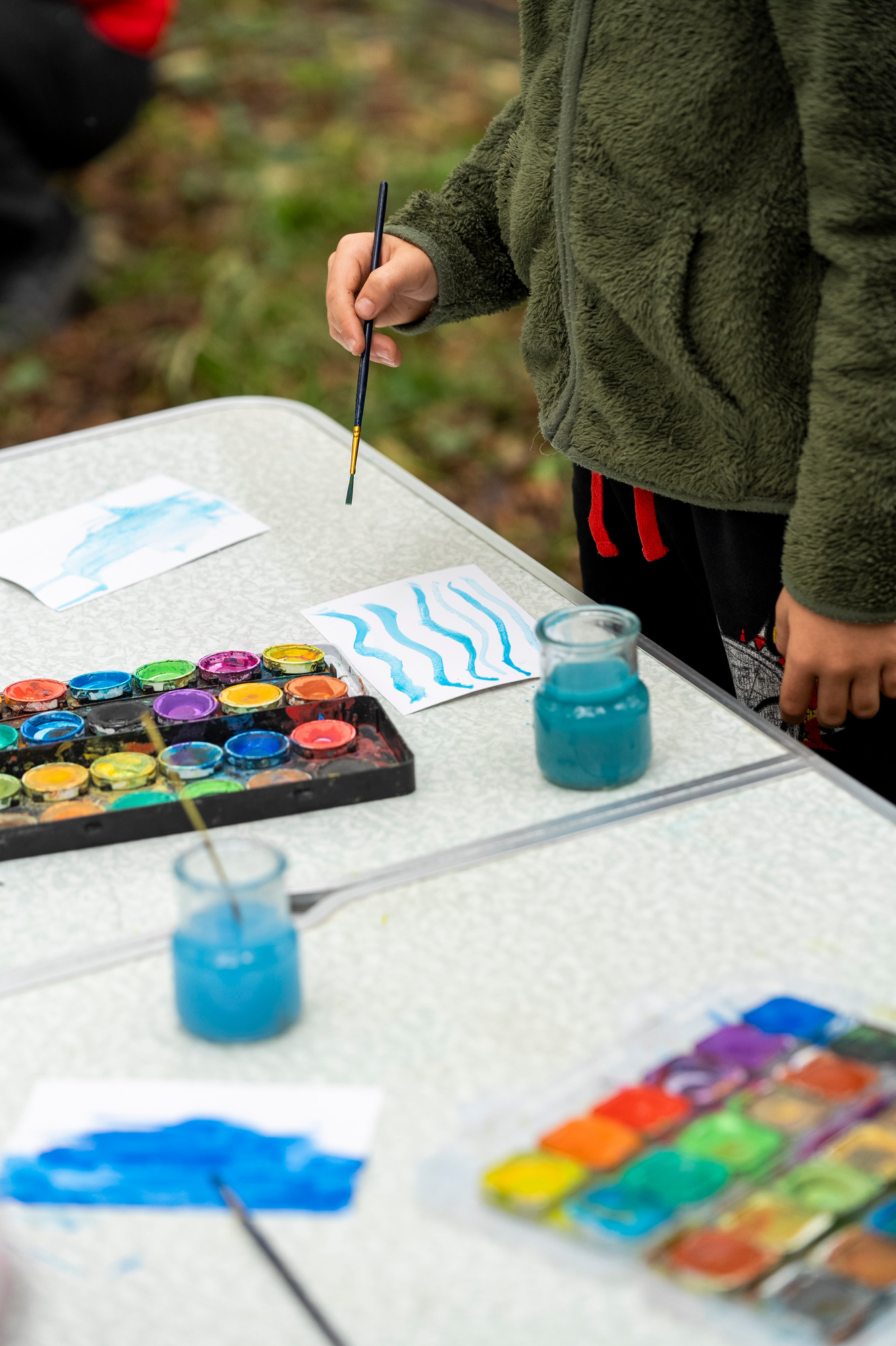 mano di bambino che colora un foglio con pennello