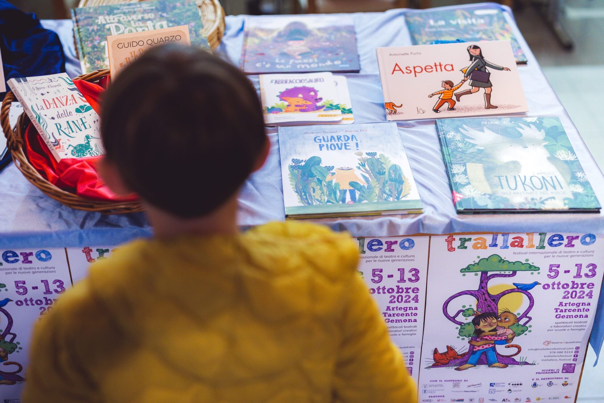bambino davanti alla bancarella dei libri esposta al festival trallallero