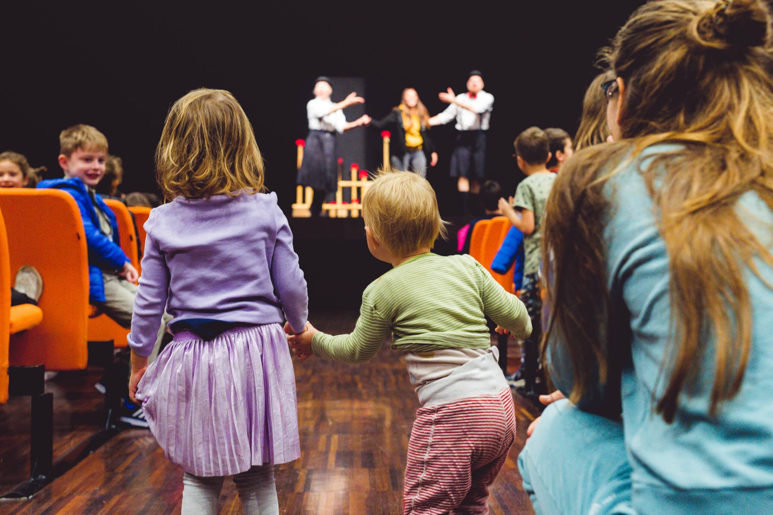due bambini della scuola dell'infanzia si tengono per mano alla fine di uno spettacolo teatrale