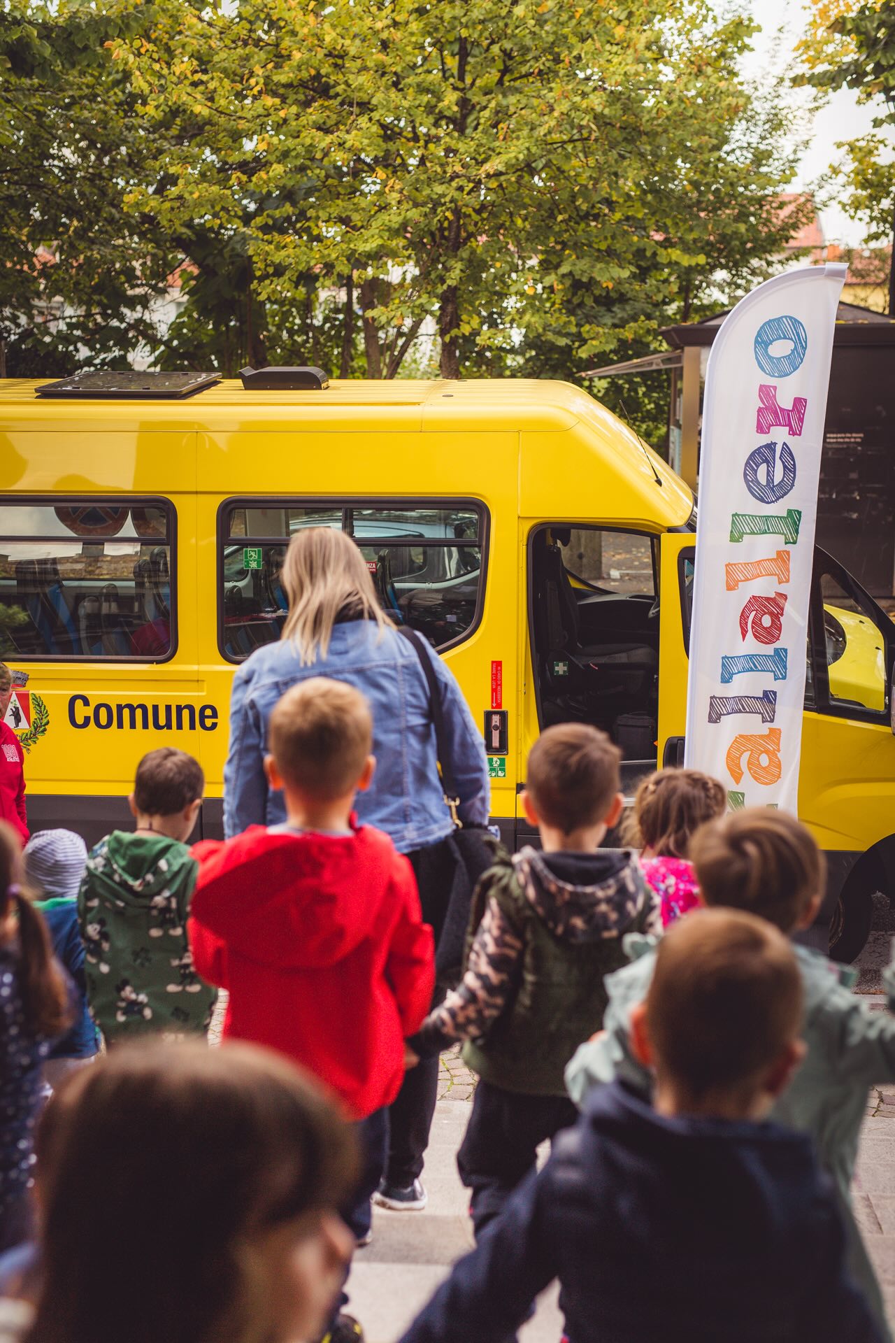 i bambini escono da teatro per salire sul pulmino giallo