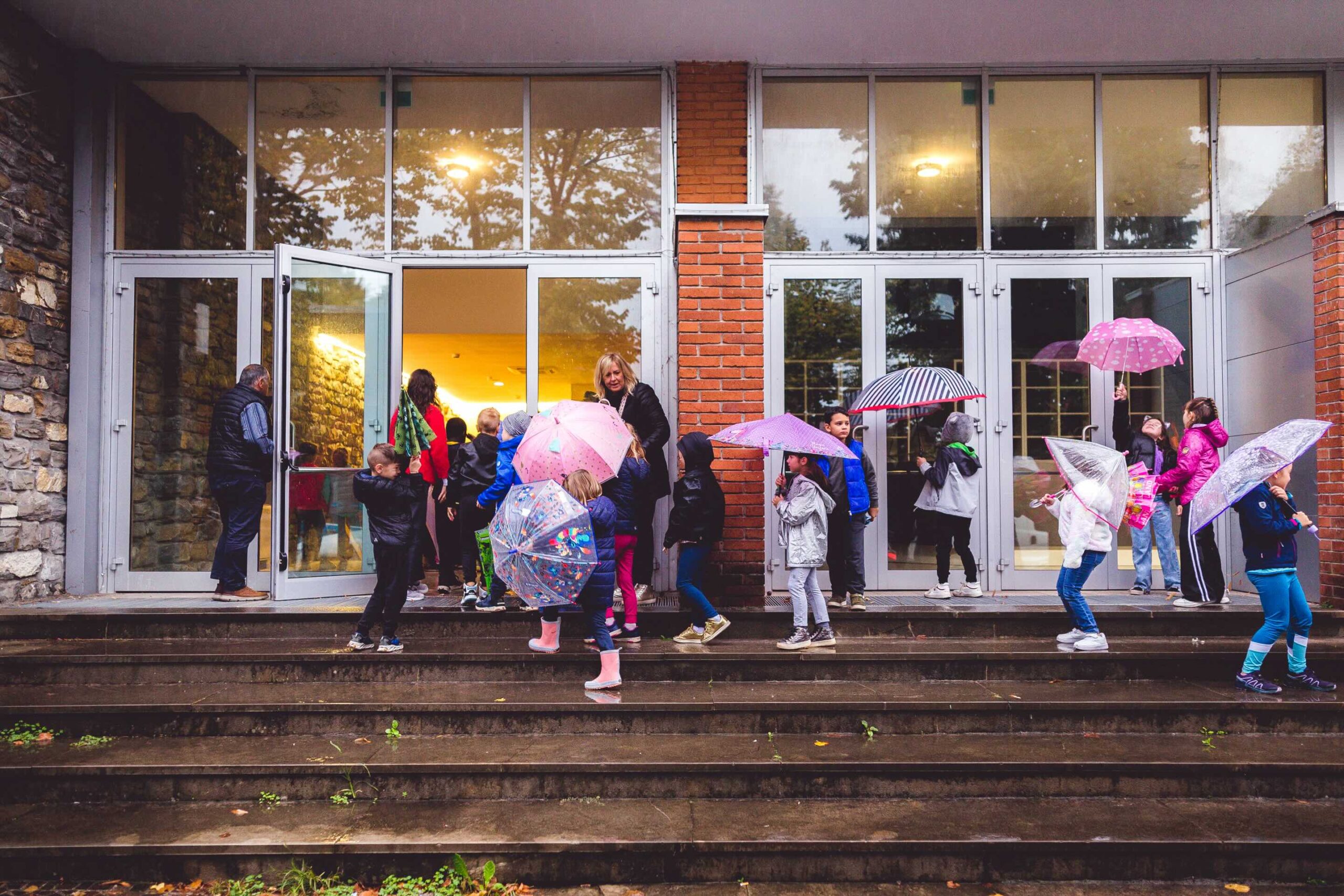 bambini con gli ombrelli davanti al teatro
